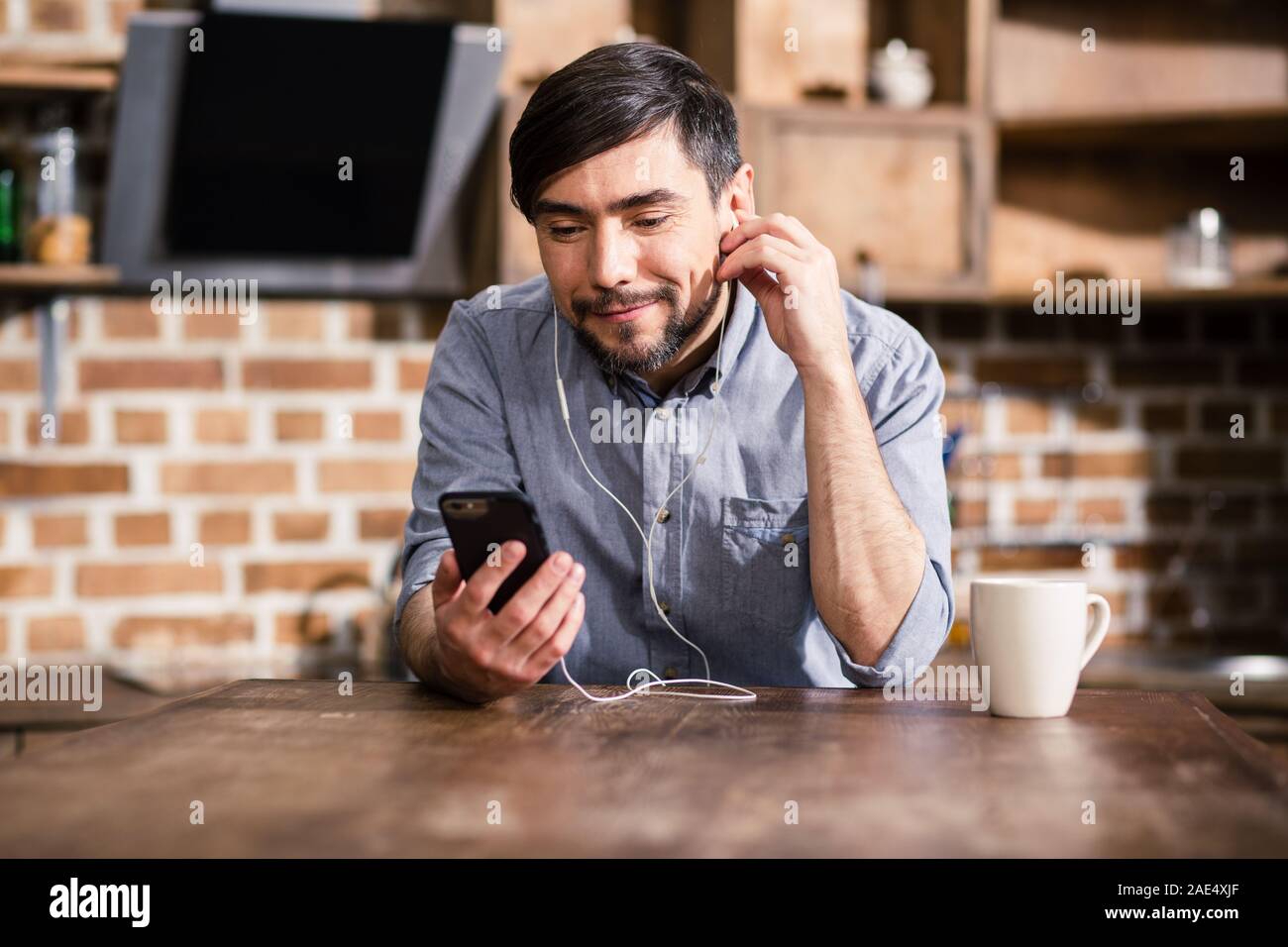 Positiver Mann mit seinem Smartphone Stockfoto