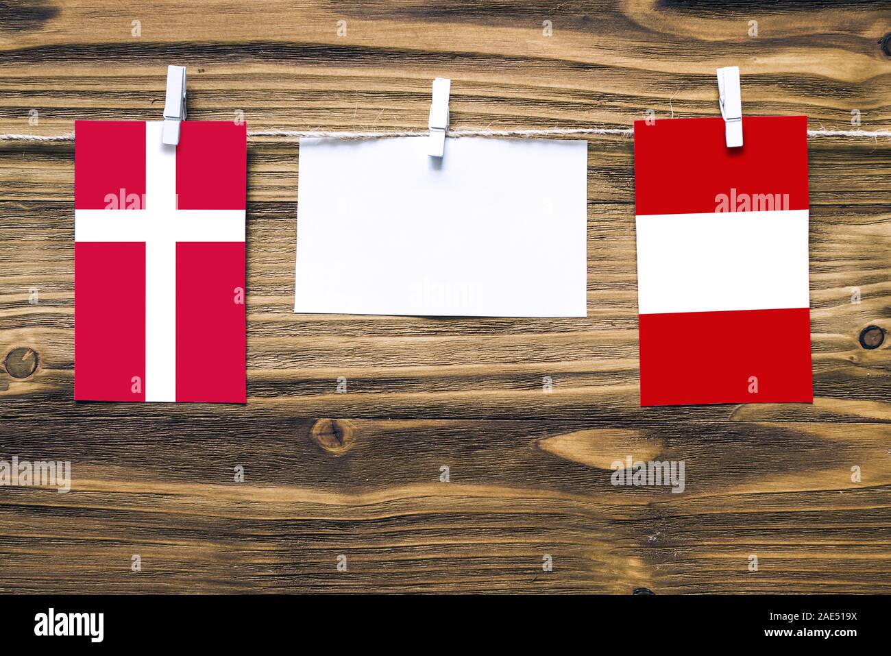 Hängenden Flaggen Dänemarks und Peru zum Seil mit Kleidung Pins mit Kopie Raum befestigt auf weißem Papier auf Holz- Hintergrund. Diplomatische Beziehungen bet Stockfoto