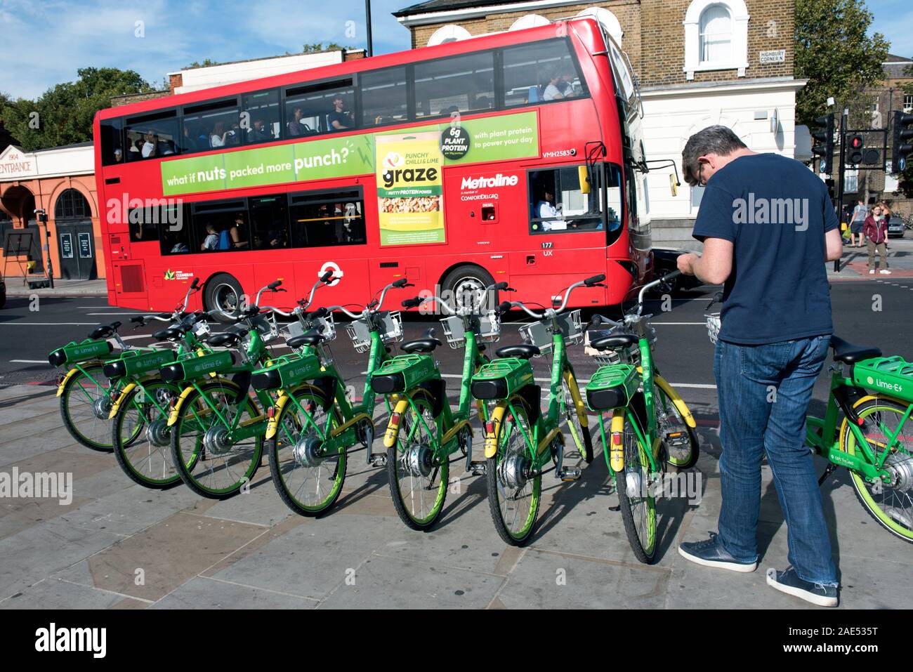 Kalk E E-Bikes auf Pflaster mit Mann und roten Bus, Holloway Road in Highbury Corner, Londoner Stadtteil Islington Stockfoto