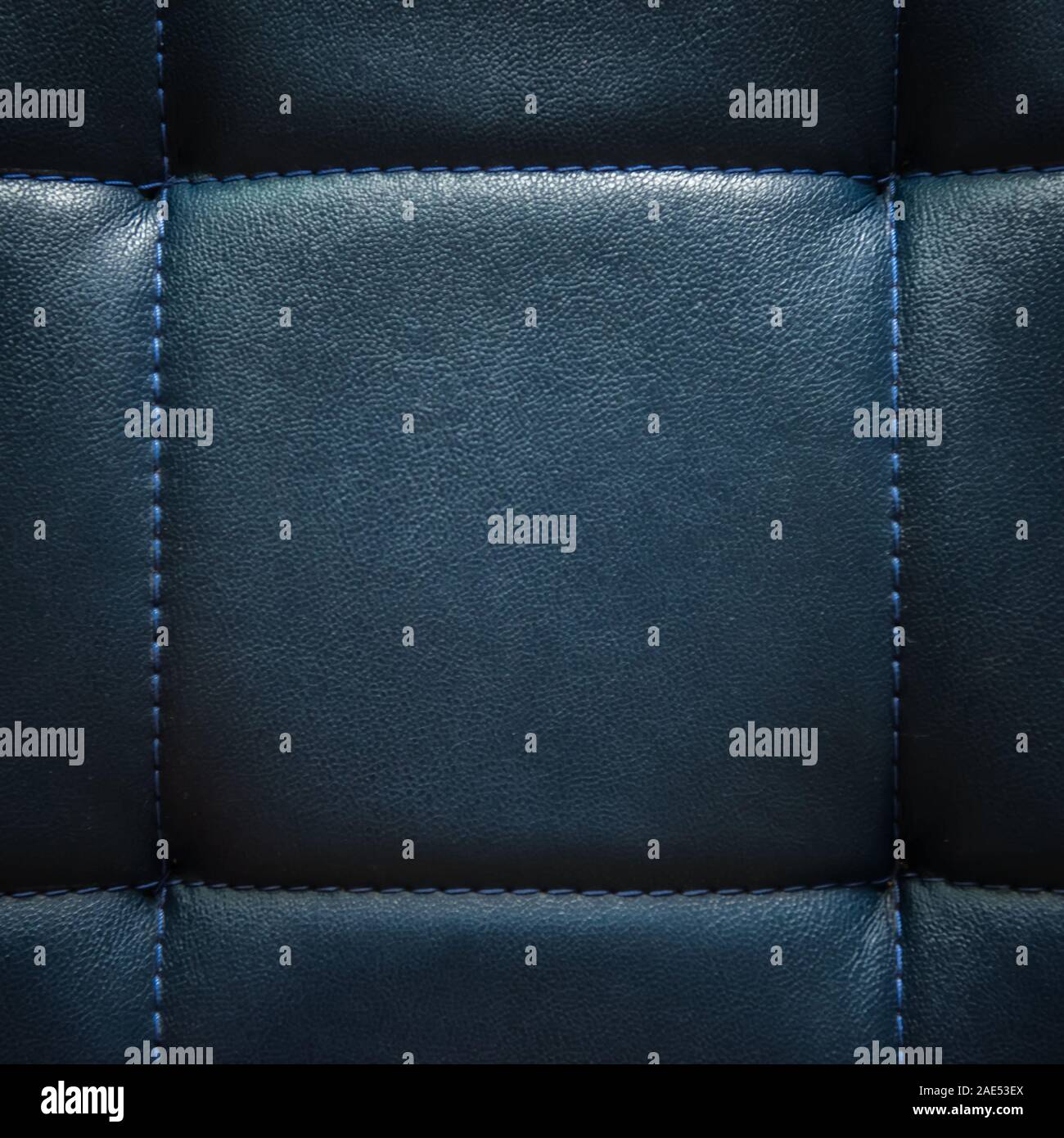 Glänzend Dunkelblau künstliche strukturiertes Leder mit blauem Faden genäht. Close-up sofa Oberfläche. Blick von direkt über. Sehr detaillierte Square zurück Stockfoto