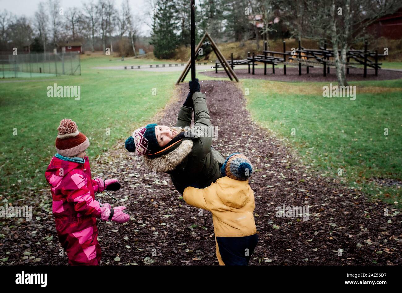 Mutter mit ihr spielen Kinder im Park spielen, auf der Schaukel Stockfoto