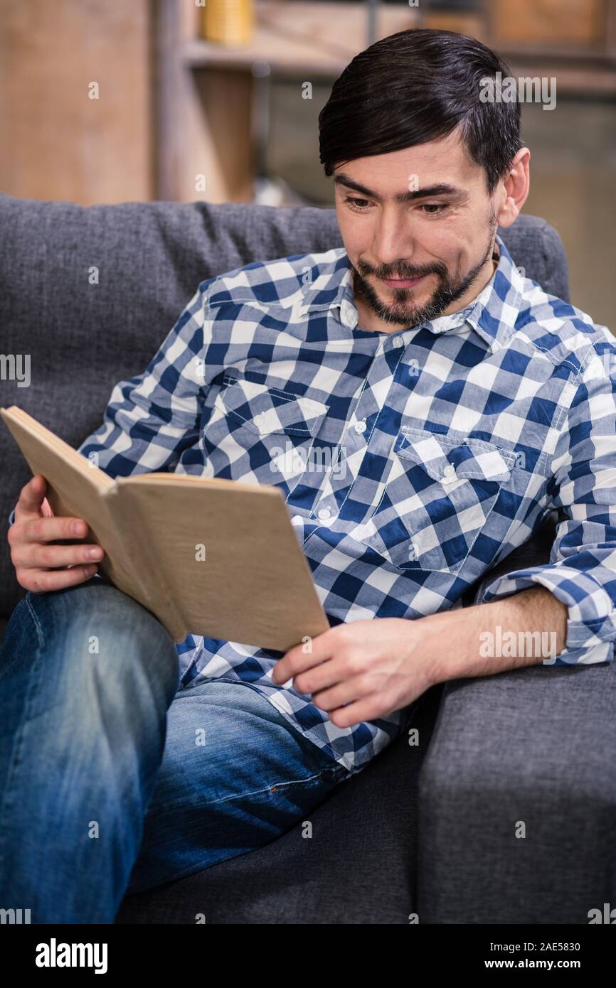 Angenehmer junger Mann ein Buch lesen Stockfoto