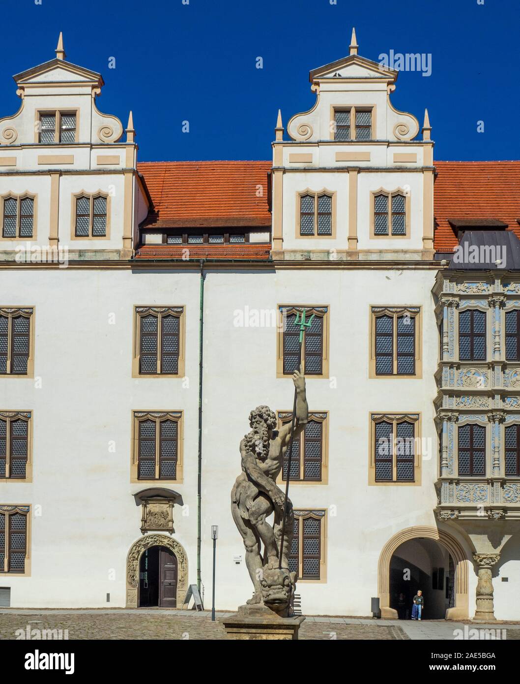 Steinstatue des Neptun in Brunnen vor dem Portal zur Burg Hartenfels Kapelle die erste evangelische Kirche der Welt Torgau Sachsen Deutschland. Stockfoto