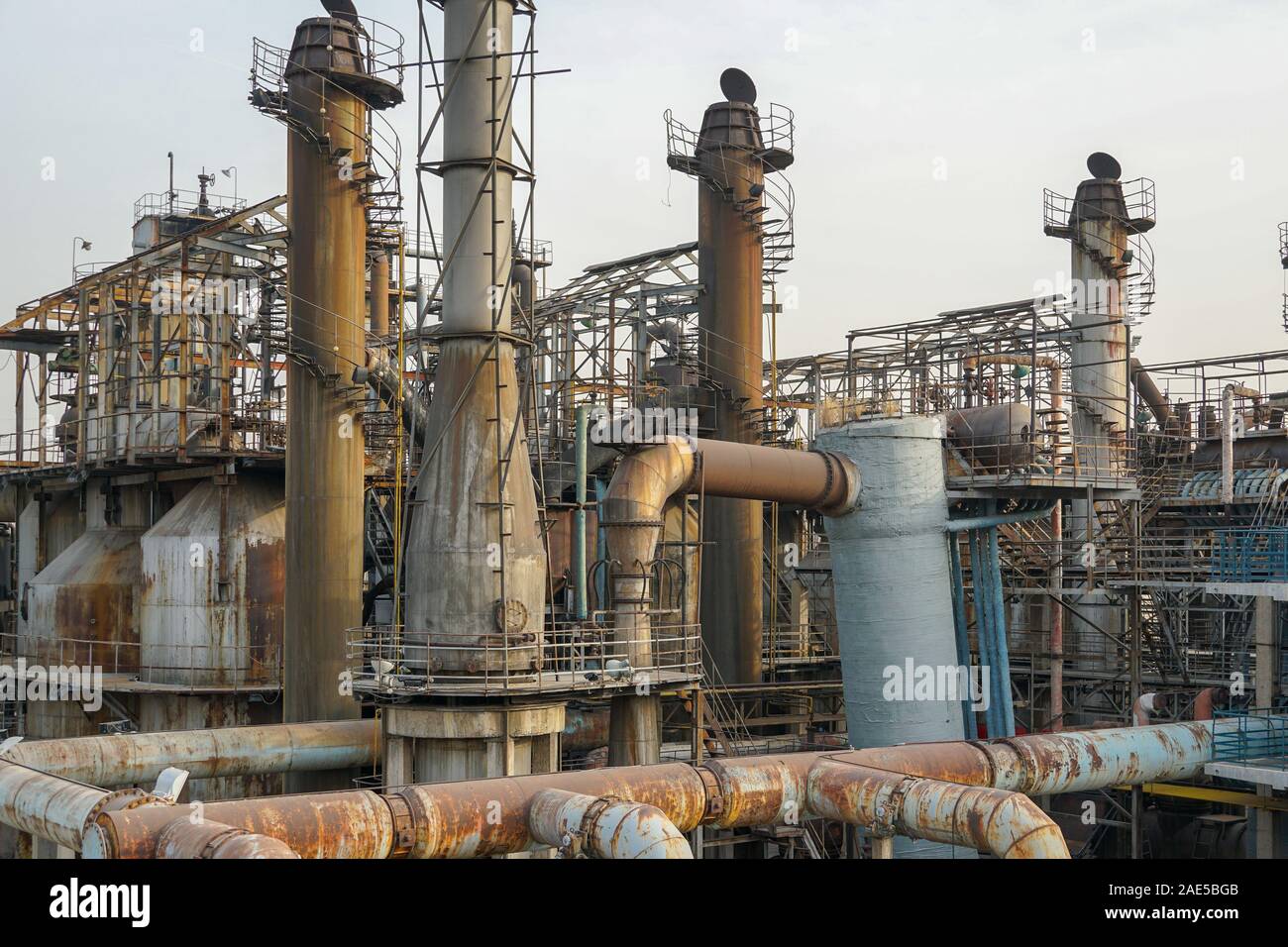 Alte Fabrik Metallkonstruktionen. Industrielle Anlage mit alten rostigen Rohren und Kühlturm für die Kühlwasserversorgung. Peking, China. Umweltverschmutzung Konzept Stockfoto