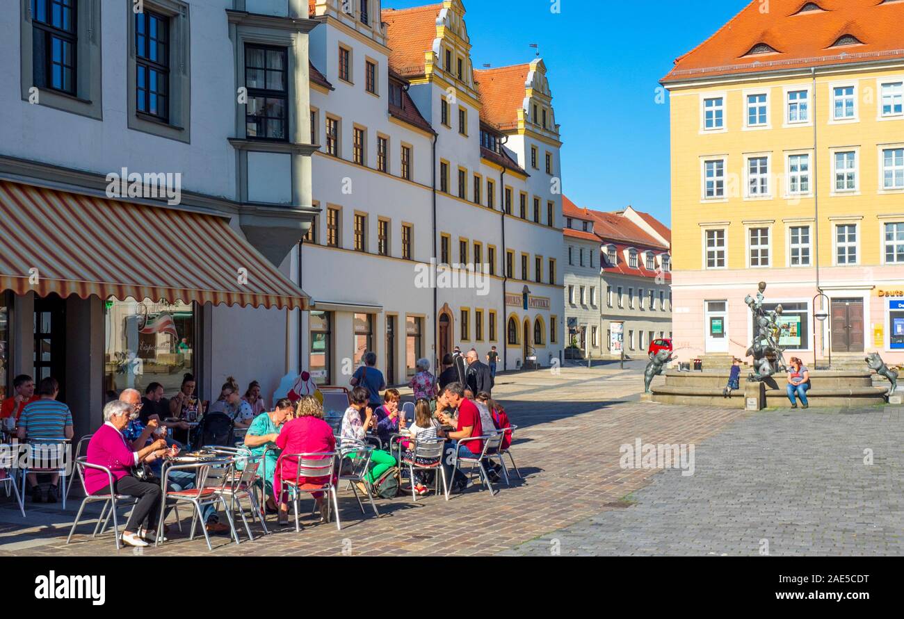Der Marktplatz ist von traditionellen Gebäuden, Hotels und Restaurants im Freien in der Altstadt Torgau Sachsen gesäumt. Stockfoto