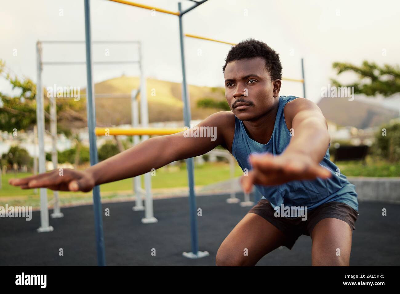 Athletischen jungen Mann in Sportkleidung, körperliche Übungen im Fitnessstudio im Freien Park - junge afrikanische amerikanische Mann hockt tun Stockfoto