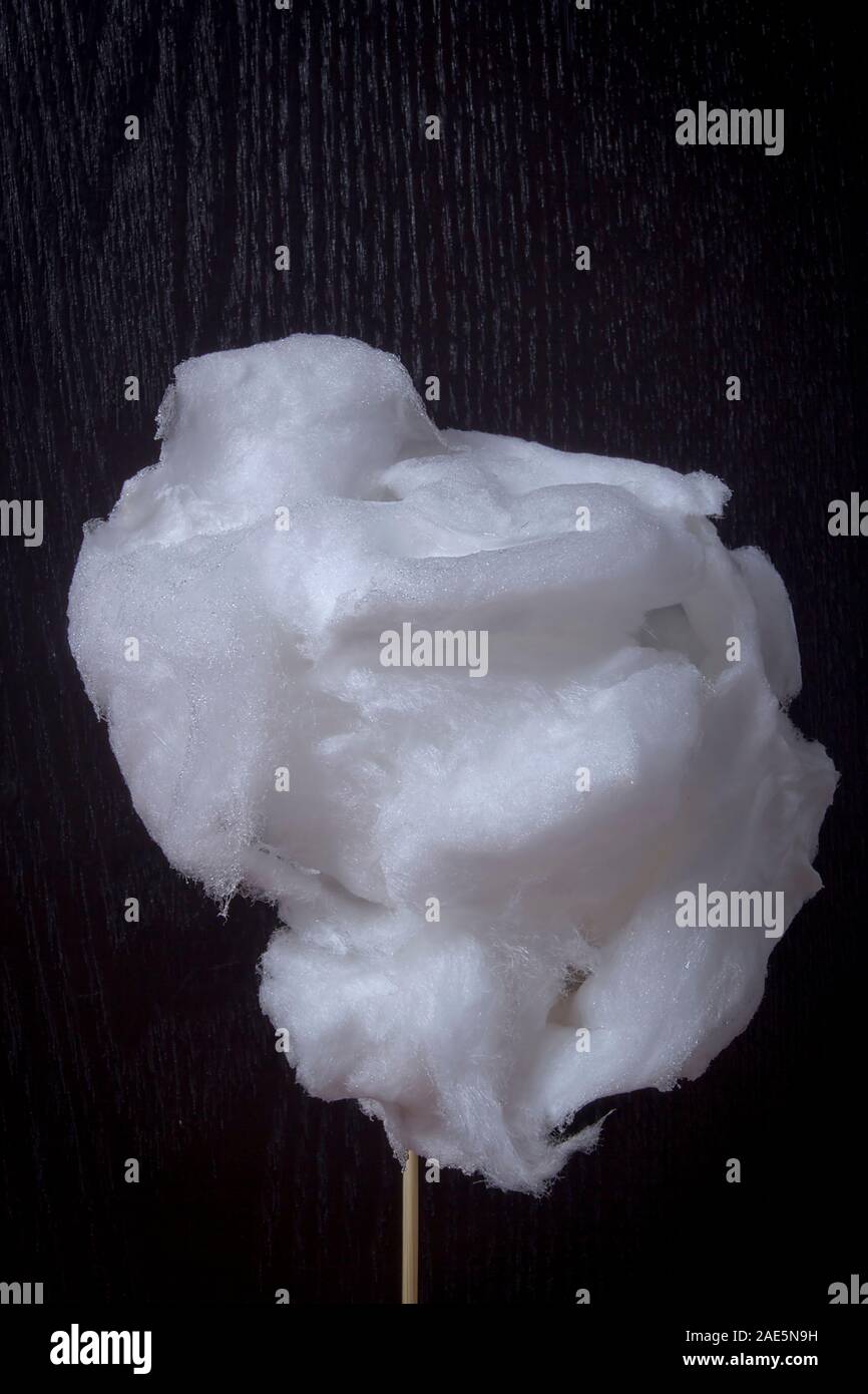 Weiße Zuckerwatte auf einem Stock auf schwarzem Hintergrund Stockfoto