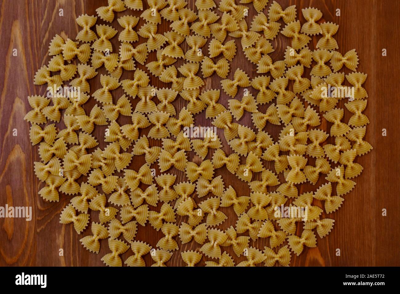 Kreis der Pasta Schmetterlinge auf einem hölzernen Hintergrund. Stockfoto