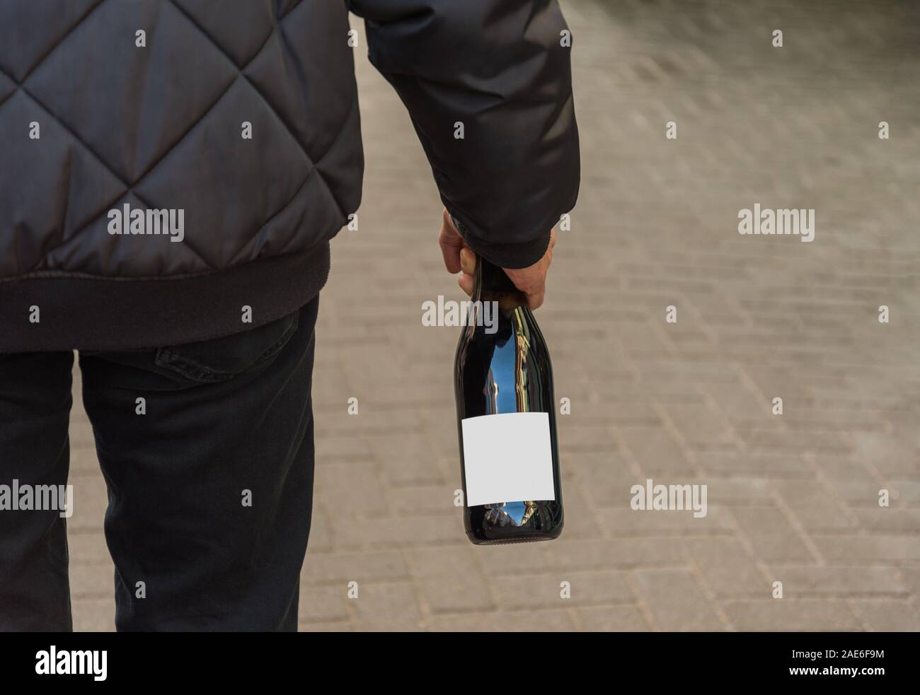 Mann Hand Flasche ohne Etikett auf der Straße. Stockfoto