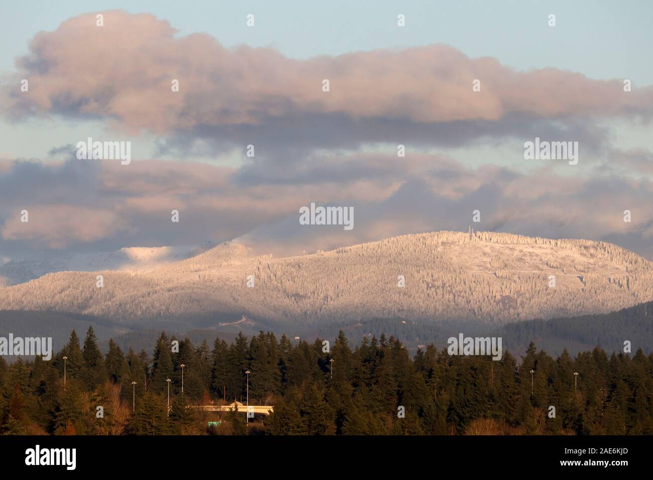 Hill zu einem höheren Höhe mit frischem Schnee bedeckt, während es kein Schnee in der Stadt unten ist. Stockfoto