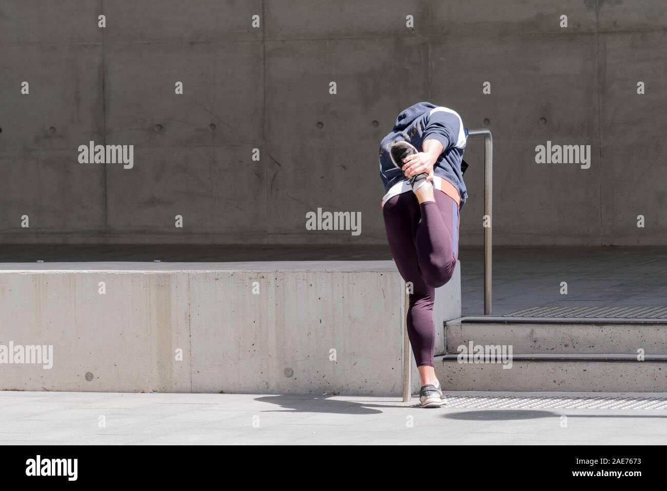 Eine hintere oder hinter den Blick auf eine Person, die mit einem Geländer aus Stahl, dehnen und Aufwärmen vor Training in Sydney, Australien Stockfoto