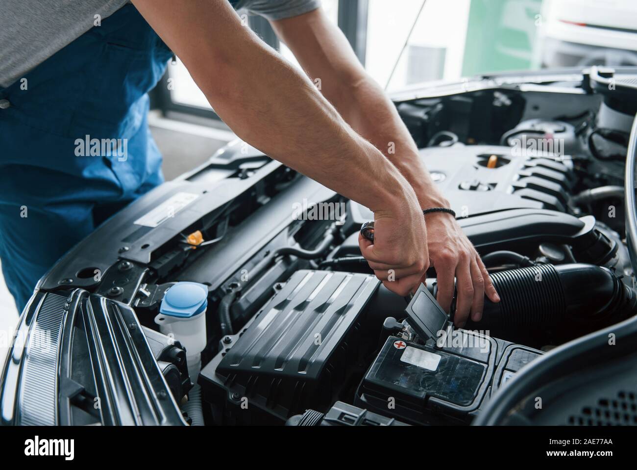 Einige elektronische Bauteile. Prozess der Reparatur Auto nach Unfall. Mann bei der Arbeit mit dem Motor unter der Haube Stockfoto
