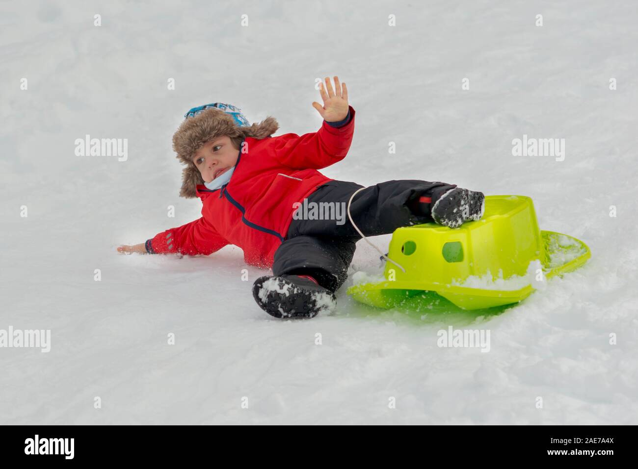 Cute kid genießen Winter fallen, vom Schlitten Stockfoto