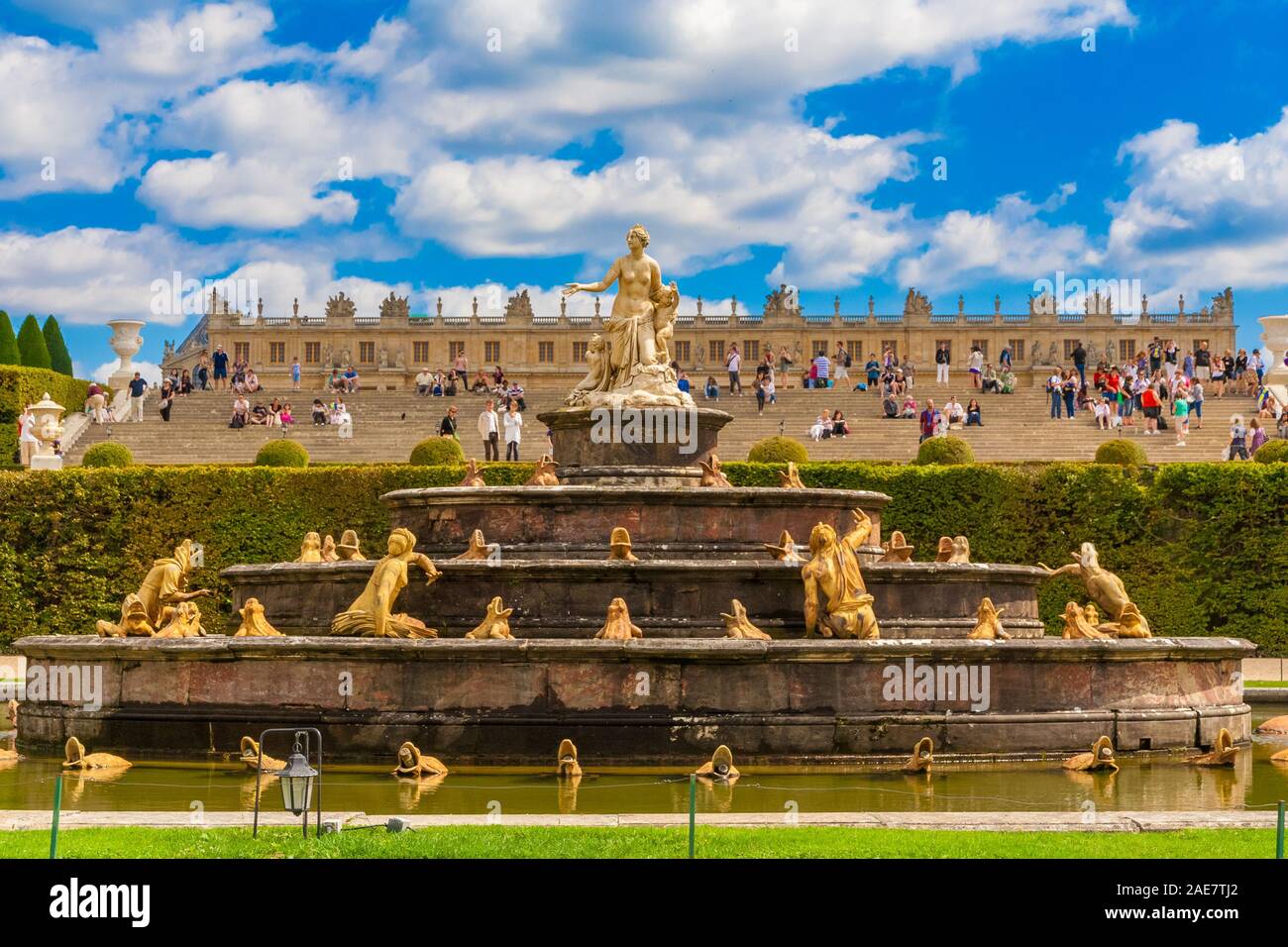 Perfekte Nahaufnahme der Latonabrunnen (Bassin de Latone) in die Gärten von Versailles mit dem Palast im Hintergrund. Auf der obersten Stufe ist ein... Stockfoto