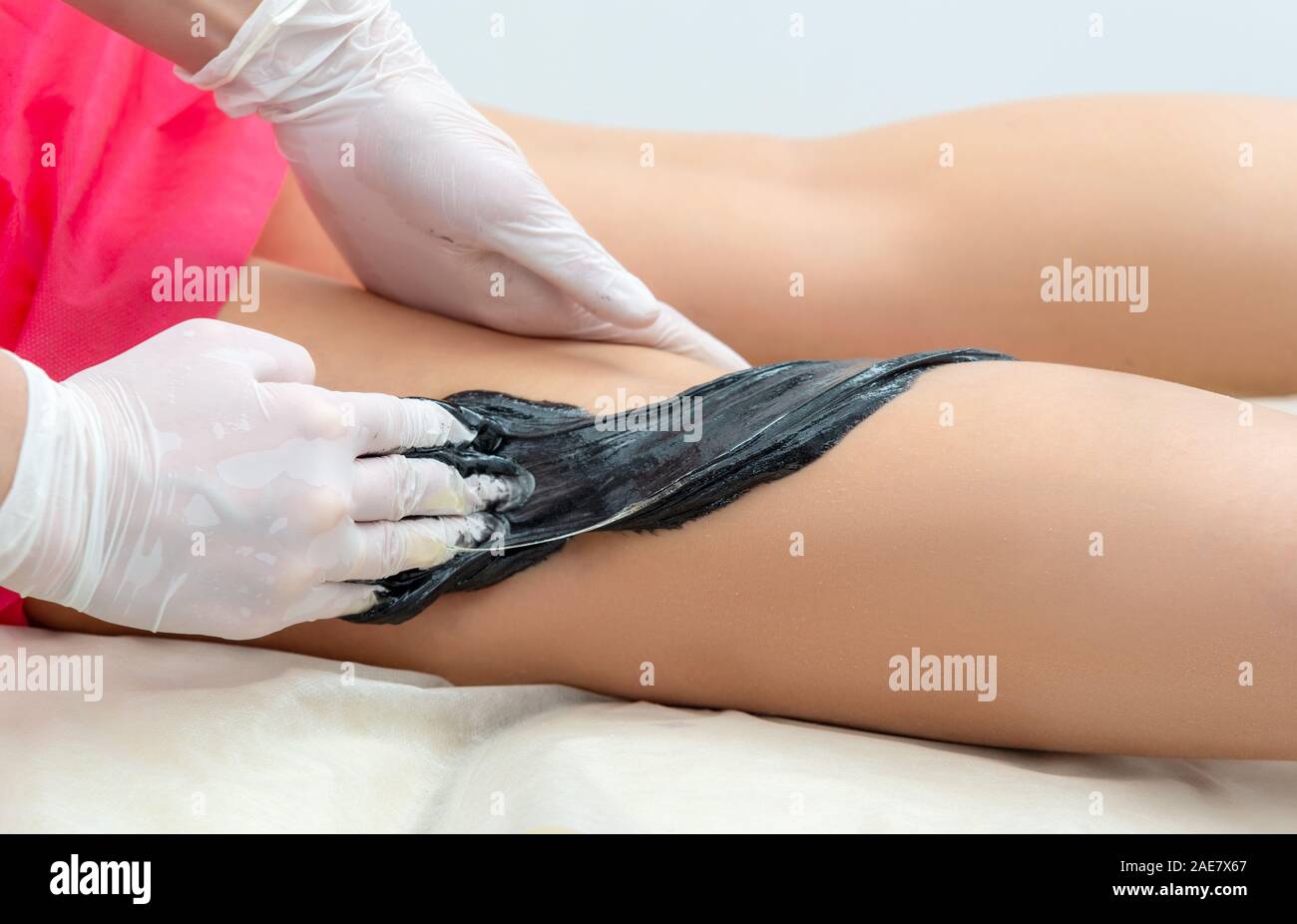 Die kosmetologin führt das Verfahren der Haarentfernung an den Beinen in der kosmetologie Büro Stockfoto