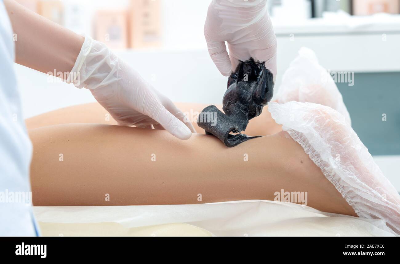 Die kosmetologin führt das Verfahren der Haarentfernung an den Beinen in der kosmetologie Büro Stockfoto