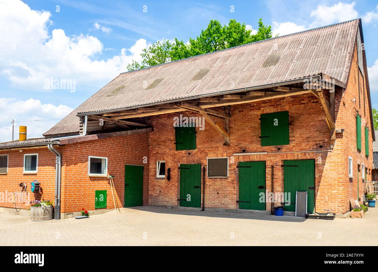 Rustikale traditionelle rote Ziegelscheune mit grün bemalten Türen auf  einem Bauernhof in Niedersachsen Deutschland Stockfotografie - Alamy