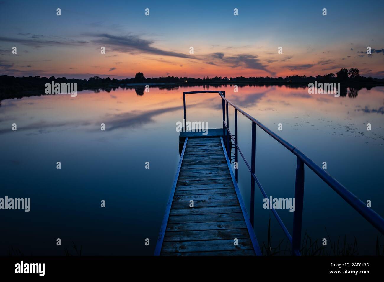 Steg auf einem ruhigen See, Wolken nach Sonnenuntergang Stockfoto