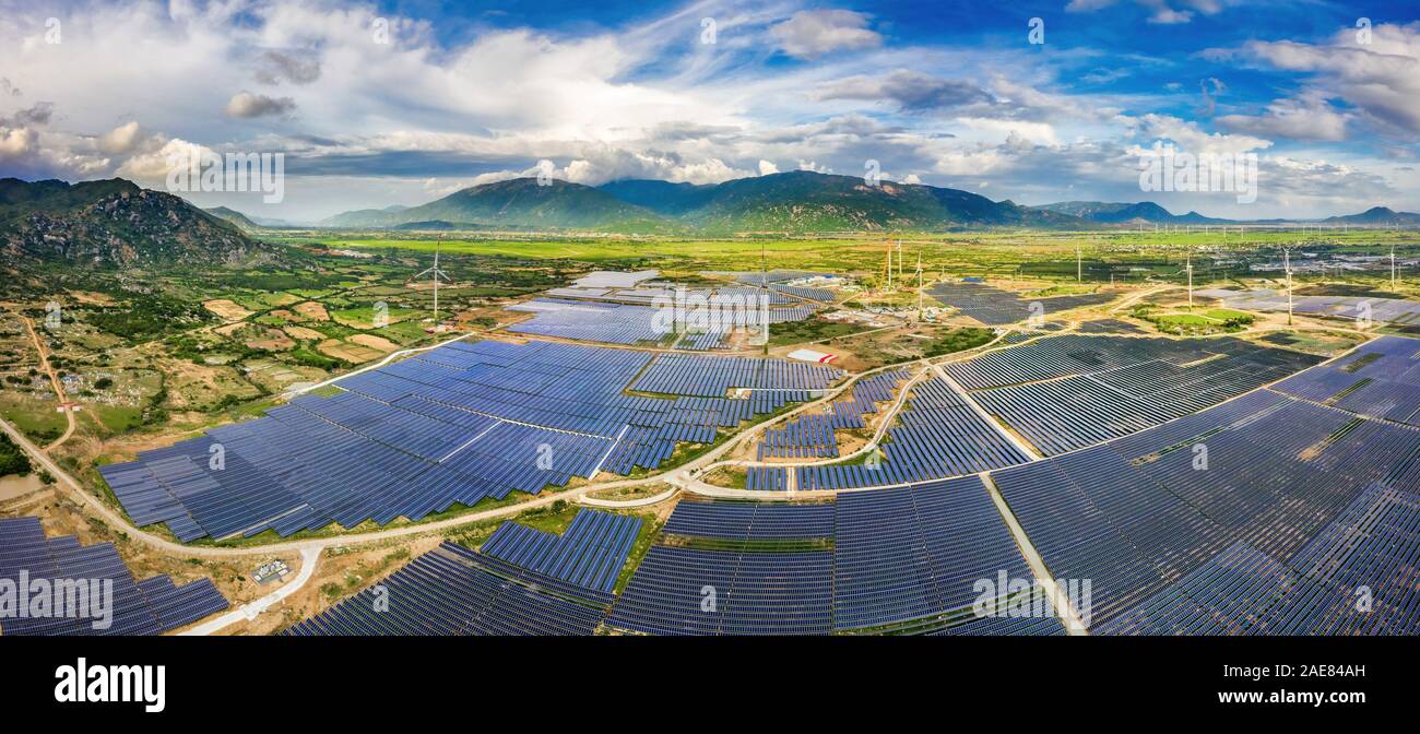 Luftbild der Sonnenkollektoren, Fotovoltaik, alternative Stromquelle mit Windkraftanlagen, Phan Rang, Ninh Thuan, Vietnam Stockfoto