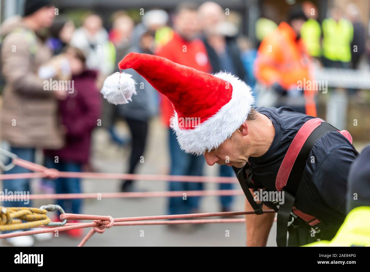 Cambridge Großbritannien 7. Dezember 2019. Feuerwehrmänner ziehen ein Feuerwehrauto, wie Tausende von Menschen die jährlichen Winter Messe in Mill Road genießen. Die Straße ist geschlossen und mit Menschen mit Musik, Essen, Tanzen, Zirkusvorstellungen, Gedichte und Performances feiern den Winter festliche Jahreszeit gefüllt. Mill Road ist für seine Vielfalt und Anzahl der unabhängigen Geschäften und Unternehmen bekannt. Credit: Julian Eales/Alamy leben Nachrichten Stockfoto