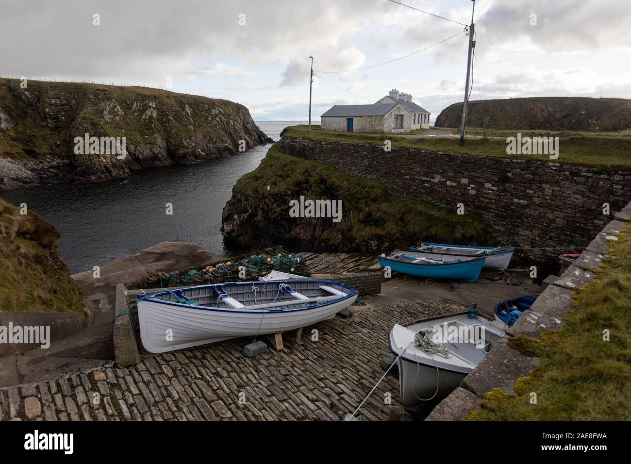 Kleiner Hafen in der Nähe von Silver Strand Strand in Malinbeg, Donegal, Irland mit kleinen Booten sicher vertäut Stockfoto