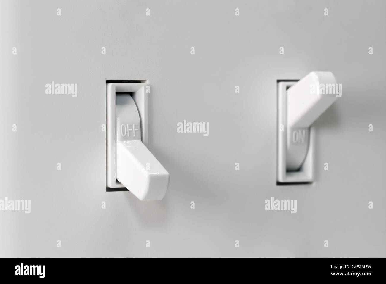 Nahaufnahme von weißem Licht Schalter ausgeschaltet und andere auf im Hintergrund mit duplex Wand Platte gedreht. Konzept der Energieeinsparung und Ressourcenschonung Stockfoto