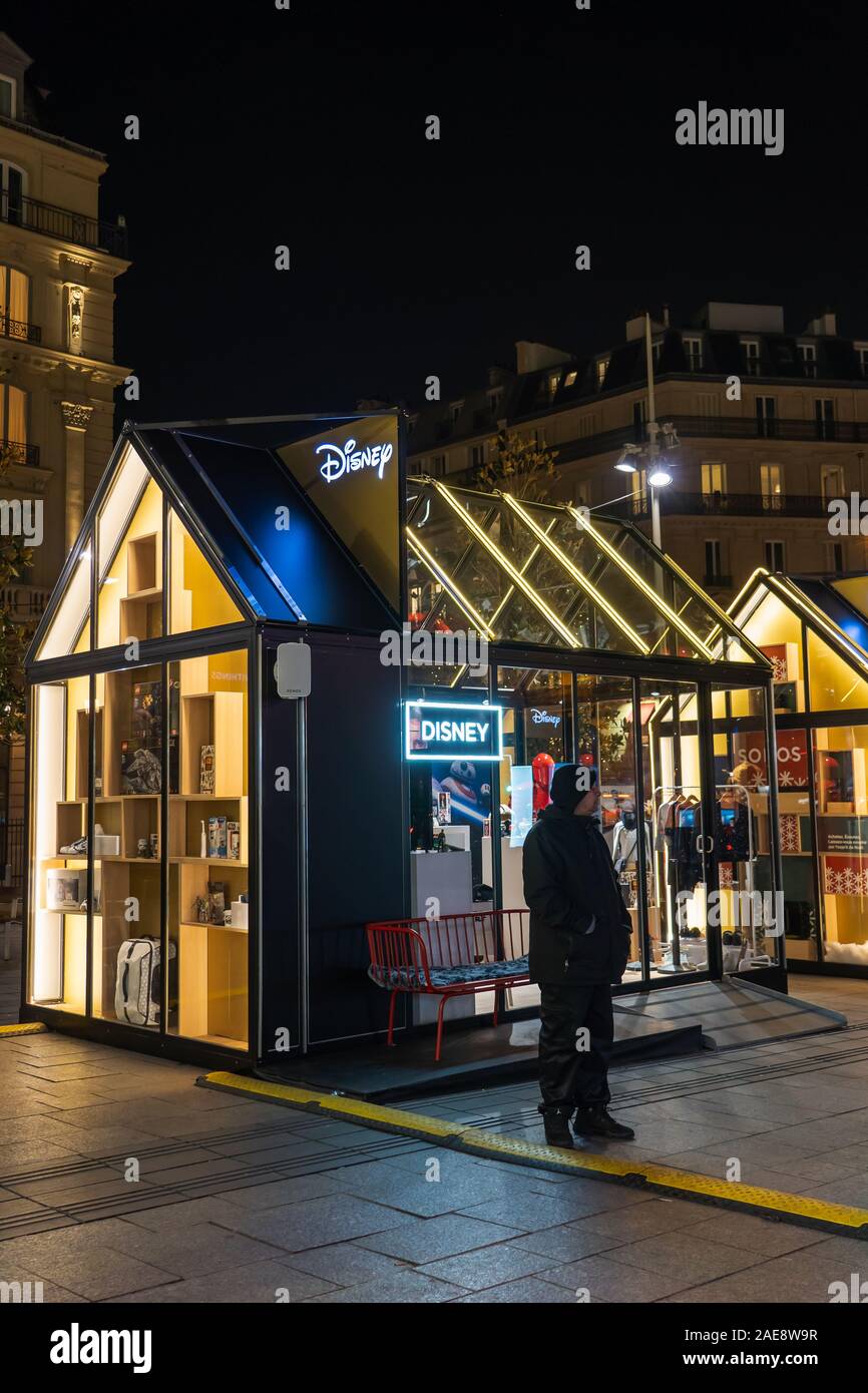 Paris, Frankreich, 4. Dezember 2019: Security Guard steht außerhalb Weihnachten Pop-up Stores von Disny in der Nähe von Bahnhof Gare St Lazare Stockfoto