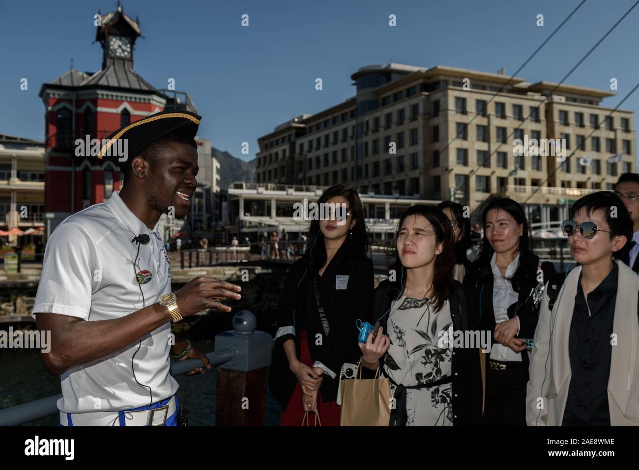 Ein Reiseleiter Chaperone chinesischen Touristen in Kapstadt Waterfront District. Südafrika ist auf der Suche nach China als Quelle des Tourismus Einnahmen Stockfoto