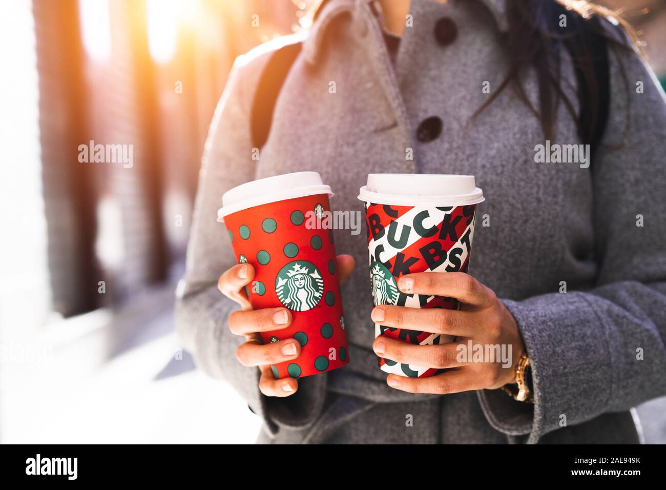 New York, USA - Dezember 5, 2019: Nahaufnahme eines Jungen Business Frau mit zwei hohen Weihnachten Starbucks Kaffee auf der Straße. Starbucks ist der worl Stockfoto