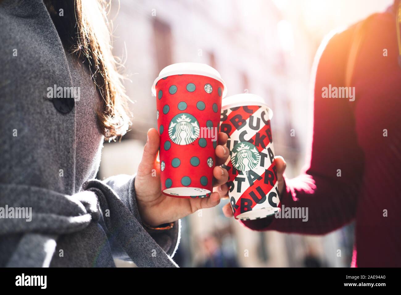 New York, USA - Dezember 5, 2019: Zwei junge Business Frau mit hohen Weihnachten Starbucks Kaffee auf der Straße bei Sonnenuntergang in New y Stockfoto