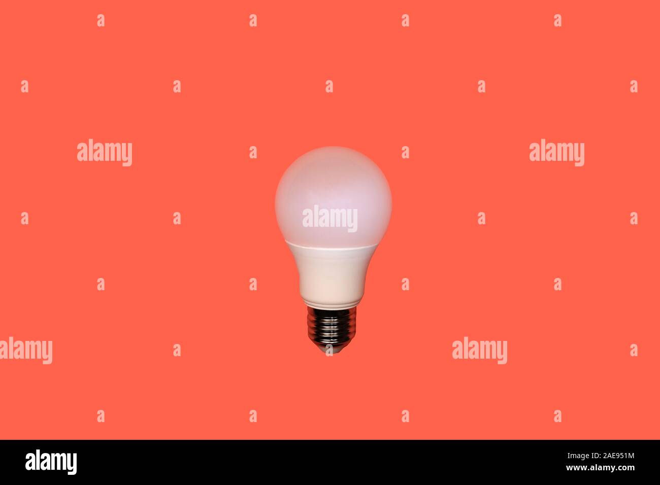Eine weiße, runde LED-Lampe mit Schraube Metall Gewinde in der Mitte auf einem roten Hintergrund, Energiesparkonzept, kopieren Raum Stockfoto