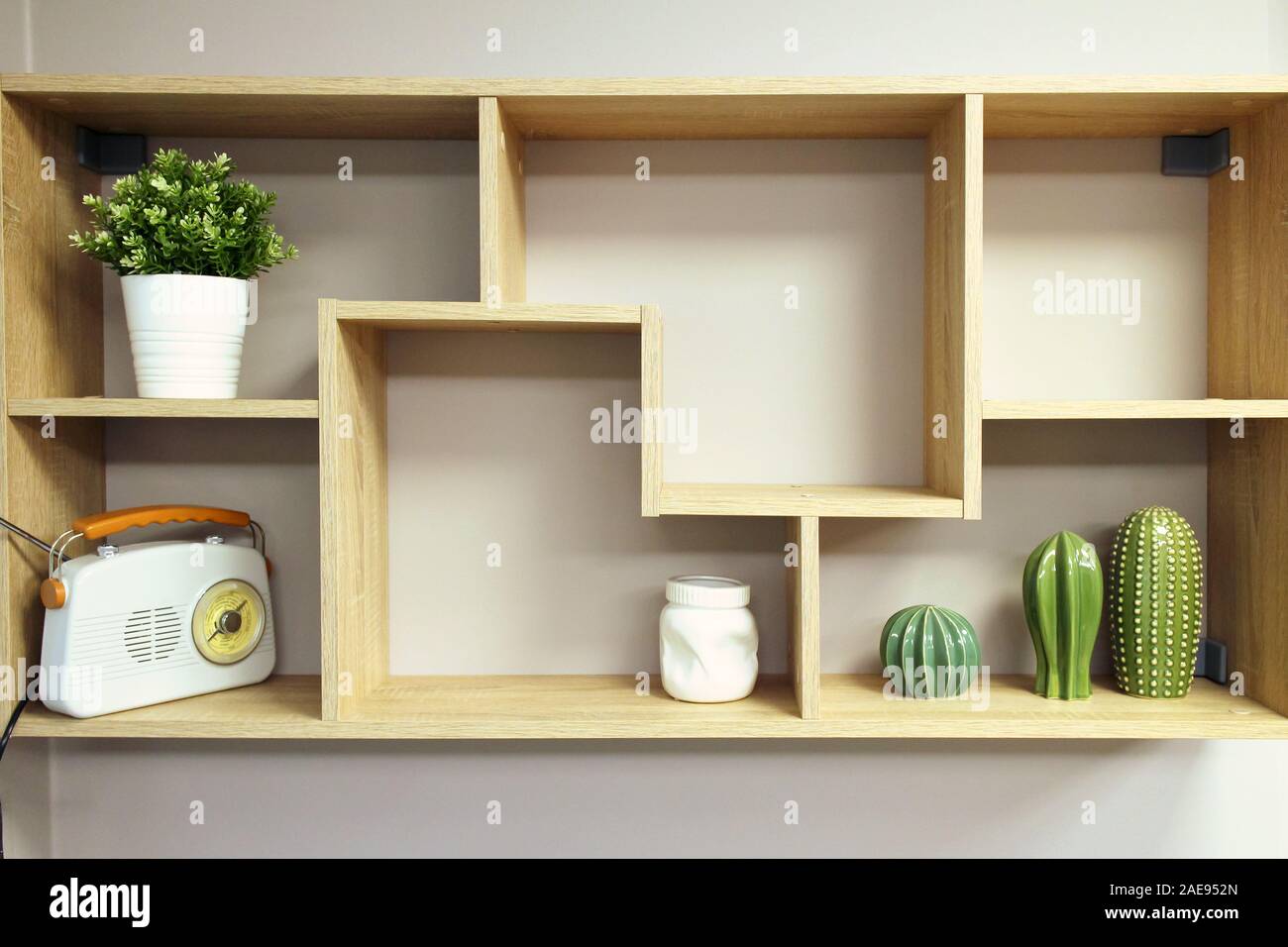 Home Innenausbau, Holz- Wandregal mit Objekten Komposition - Vase, dekorative Elemente aus Keramik, Topf mit Pflanze, retro style Radio Stockfoto