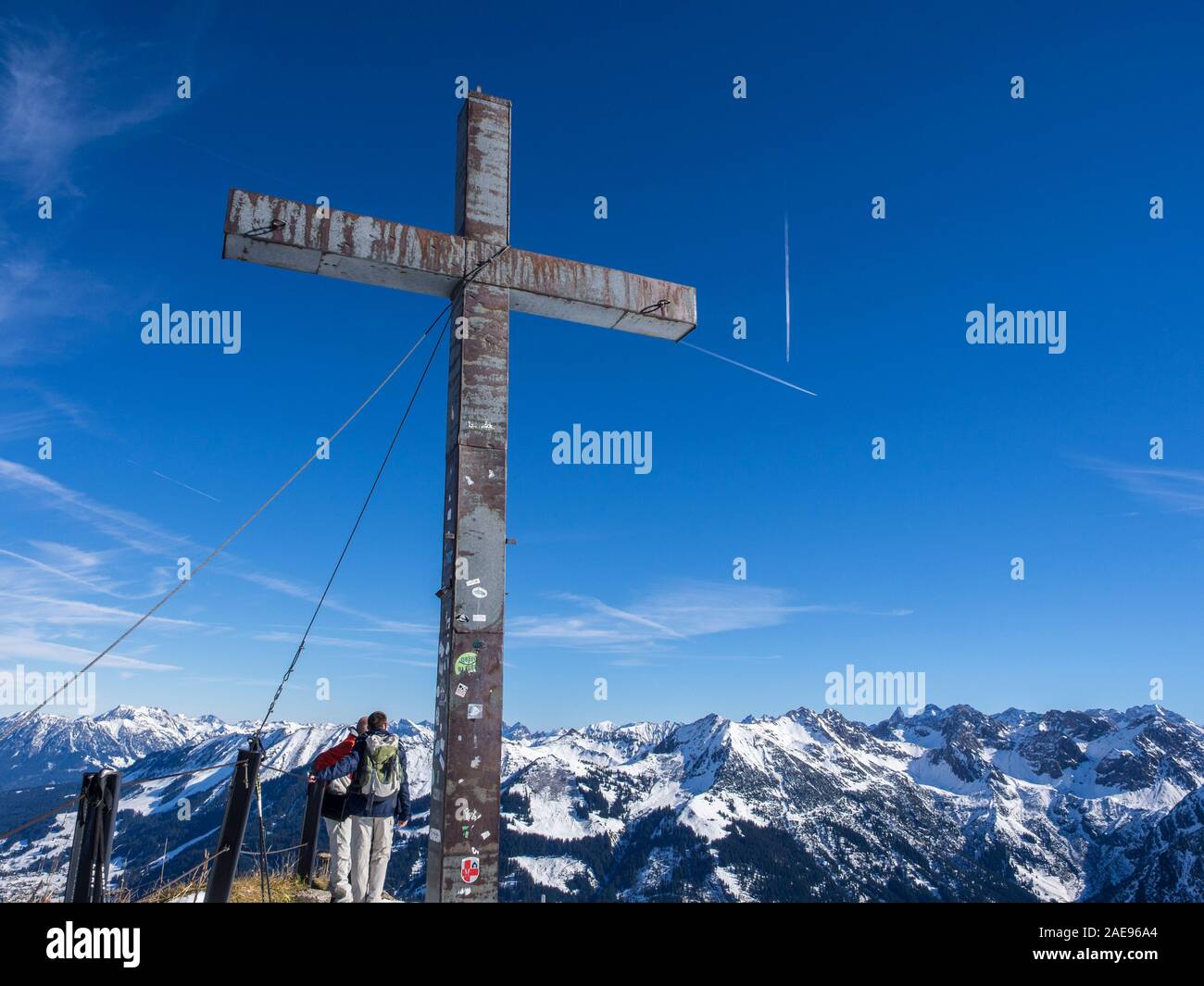 Gipfelkreuz vor blauem Himmel, Wanderer, auf der Oberseite der Walmendingerhornbahn, Allgaue, Tal Kleinwalsertal, Vorarlberg, Österreich Stockfoto