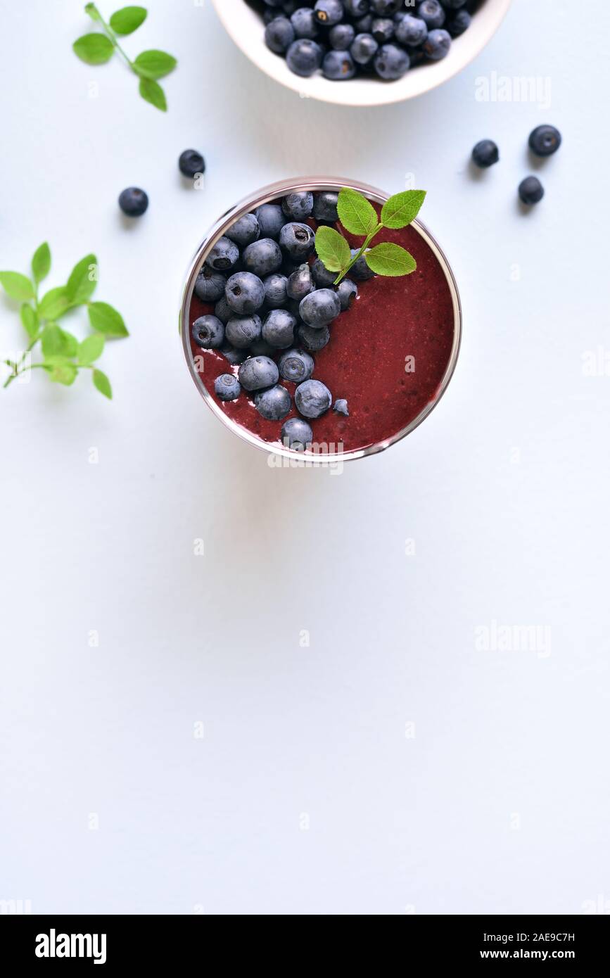 Gesundes natürliches Getränk. Blueberry Smoothie in Glas auf hellem Stein Hintergrund mit kopieren. Ansicht von oben, flach Stockfoto