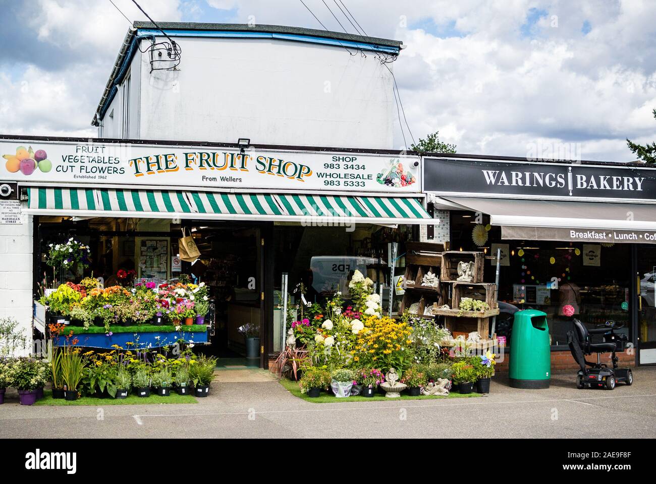 Exterieur des Fruit Shop - unabhängige, familiengeführte grüne Lebensmittelhändler im ländlichen Berkshire, England. Regale von Pflanzen auf dem Straßenbelag draußen. Stockfoto