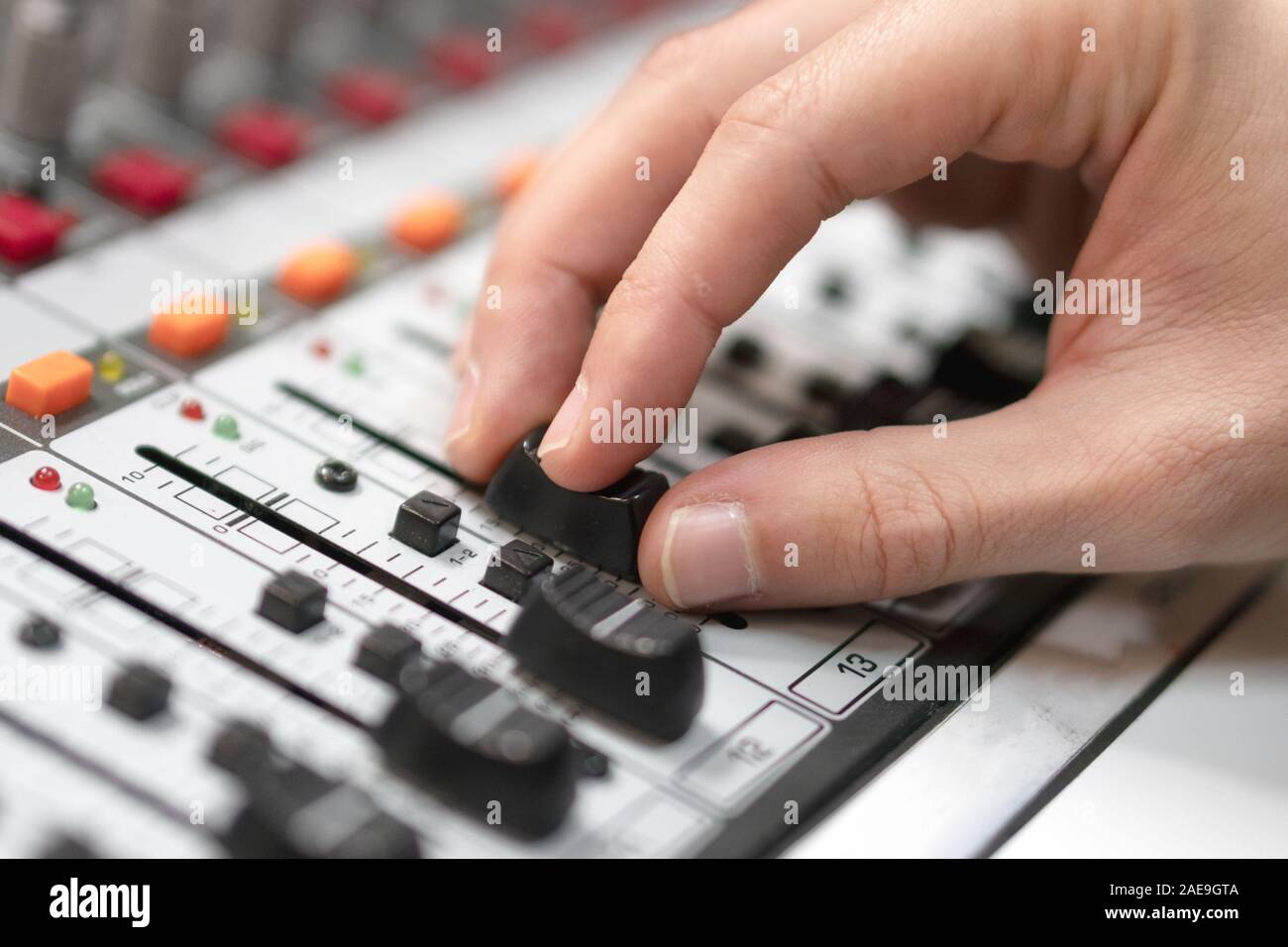 Männliche Hand auf der Fader auf der Konsole. Sound Recording Studio Mischpult mit dem Ingenieur oder Musikproduzent. Stockfoto