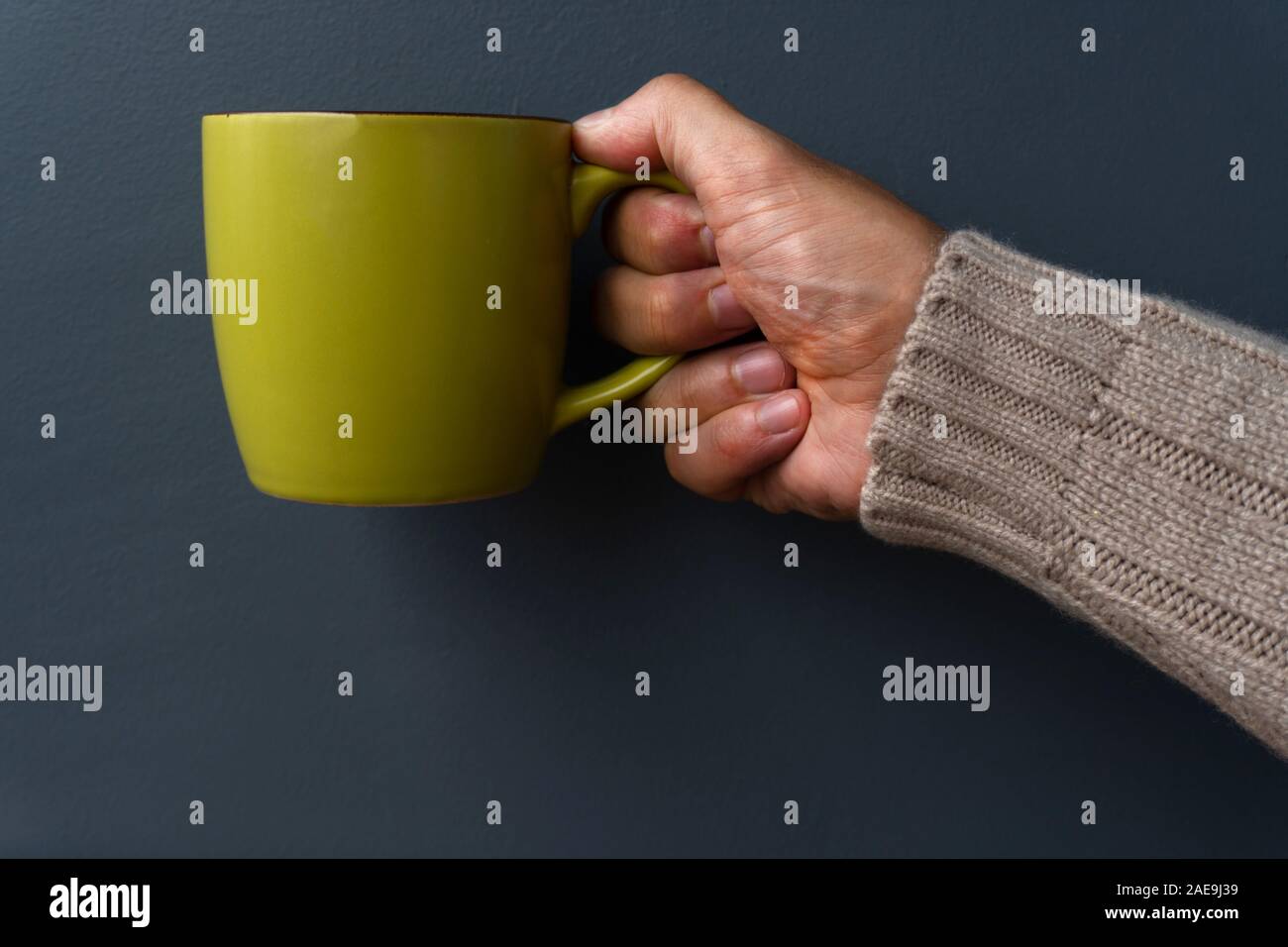 Mann hält Grün Becher Stockfoto