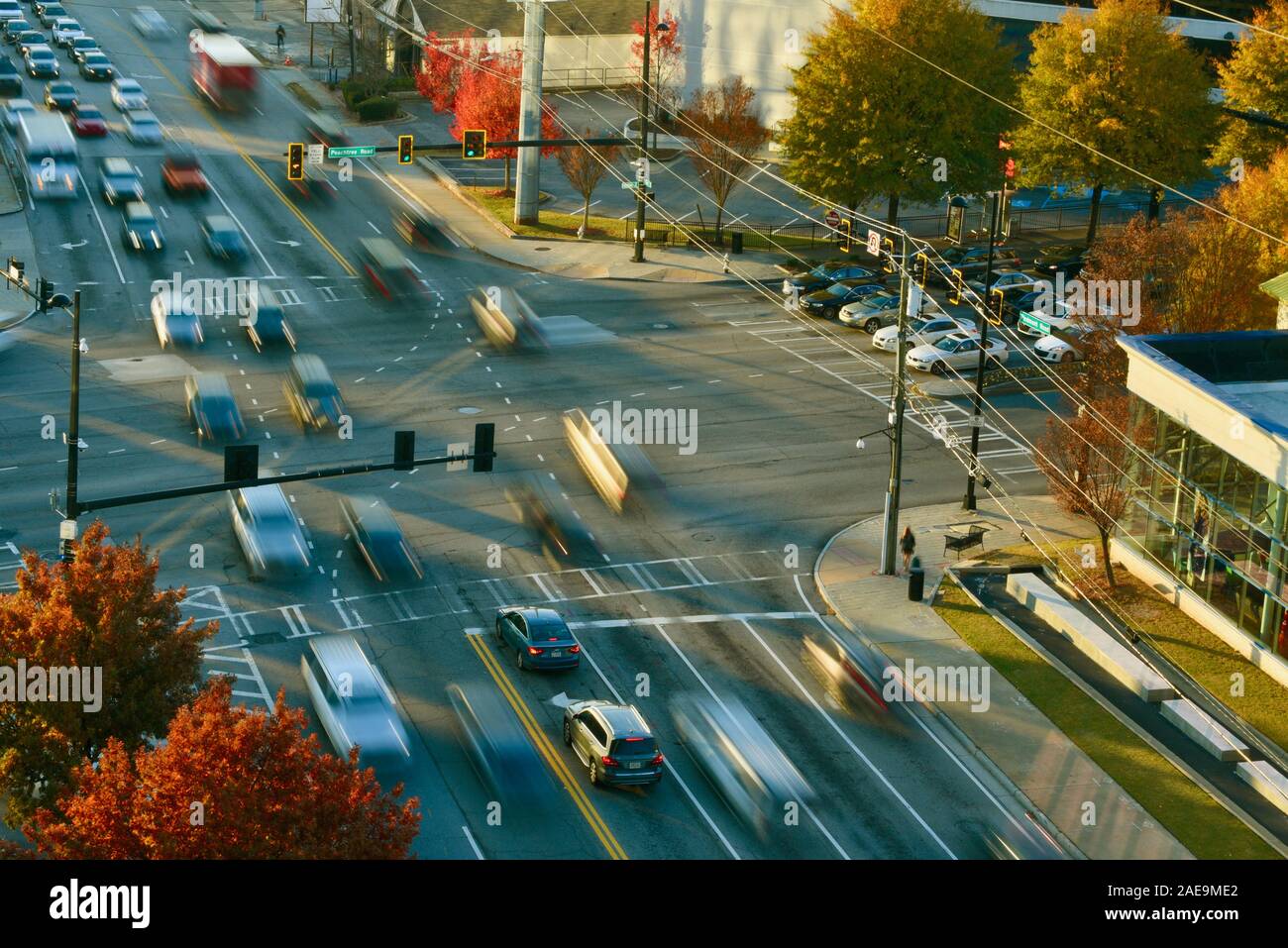 Am frühen Morgen pendeln Fahrzeug Verkehr (Motion Blur), verkehrsreichen Kreuzung, mit Menschen zu Fuß auf Fussgängerstreifen zu arbeiten, Buckhead, Atlanta, Georgia, USA. Stockfoto