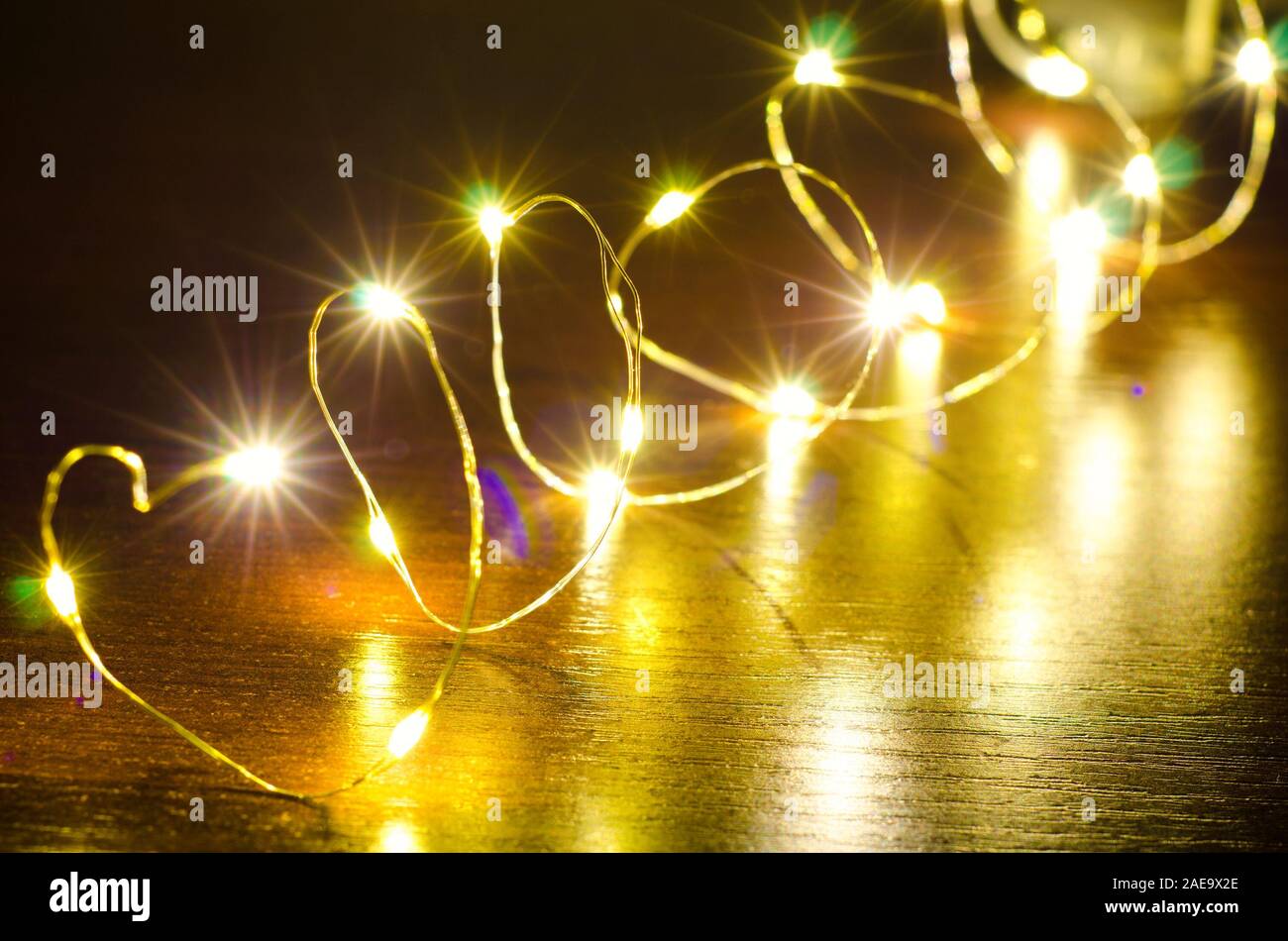 Weihnachtsgirlande Licht auf einem hölzernen Hintergrund Stockfoto