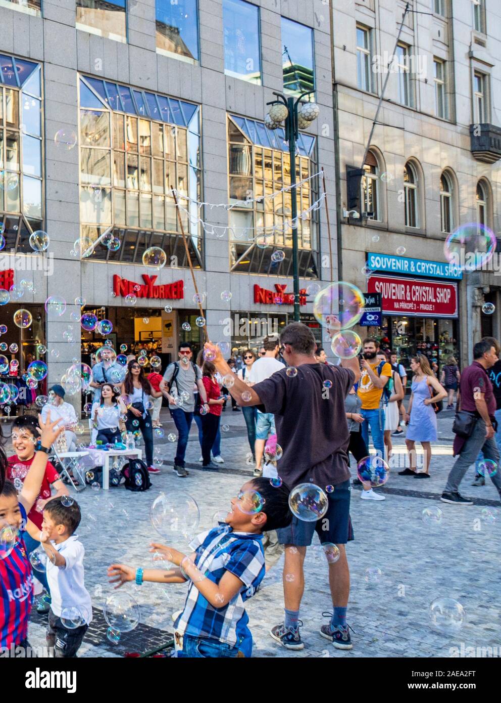 Mann, der Blasen macht und Kinder, die versuchen, die Blasen in der Altstadt Prag Tschechische Republik zu fangen. Stockfoto