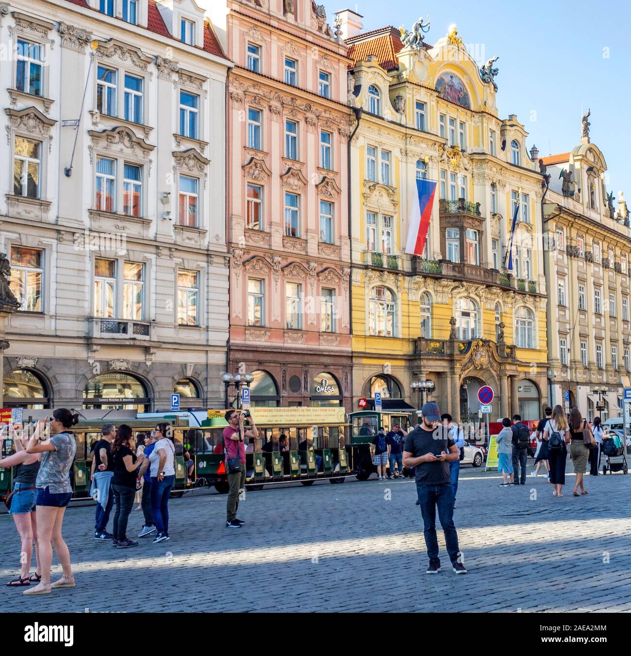 Mock-Trolley-Zug und Touristen vor dem ehemaligen Gebäude der Prager Stadtversicherung in der Altstadt Platz Prag Tschechische Republik. Stockfoto