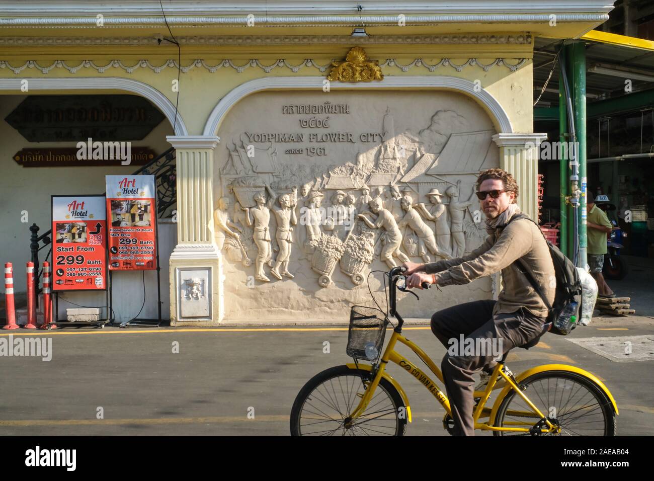 Ein Tourist auf einer Radtour durch Bangkok übergibt einen Fries mit Markt nutze; Yodpiman Blumenmarkt, Pak Klong Talaat, Bangkok, Thailand Stockfoto