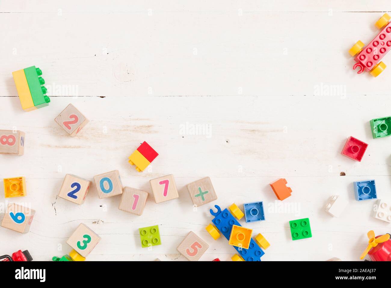 Draufsicht auf Holz Würfel mit Zahlen und bunten Kunststoff Ziegel auf weiße Holztisch Hintergrund. Schule, Bildung und Lernen Konzept. Stockfoto