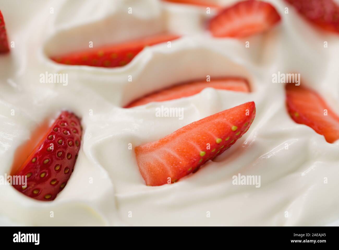 Nahaufnahme von frisch gehackte Erdbeeren in weißer Joghurt, flachen Fokus Stockfoto