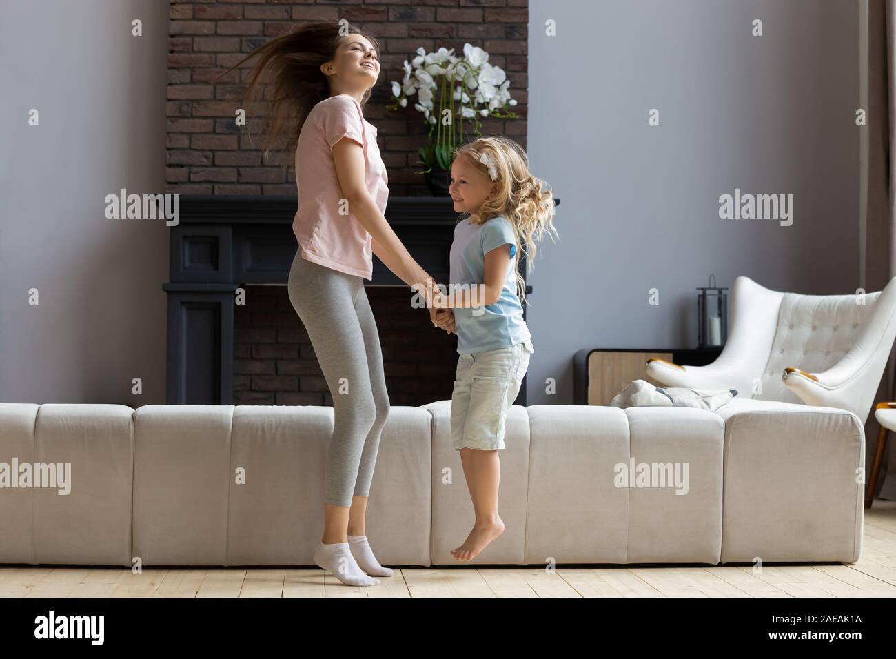 Mutter mit Tochter halten sich an den Händen Tanzen genießen Wochenende zusammen Stockfoto