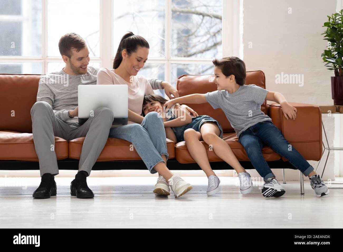 Glückliche Familie mit zwei Kindern eine gute Zeit mit Laptop. Stockfoto