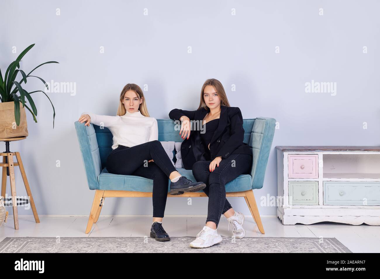 Zwei Mädchen sitzen zusammen auf dem Sofa. Freundschaft und jugendlicher Beziehungen. Stockfoto