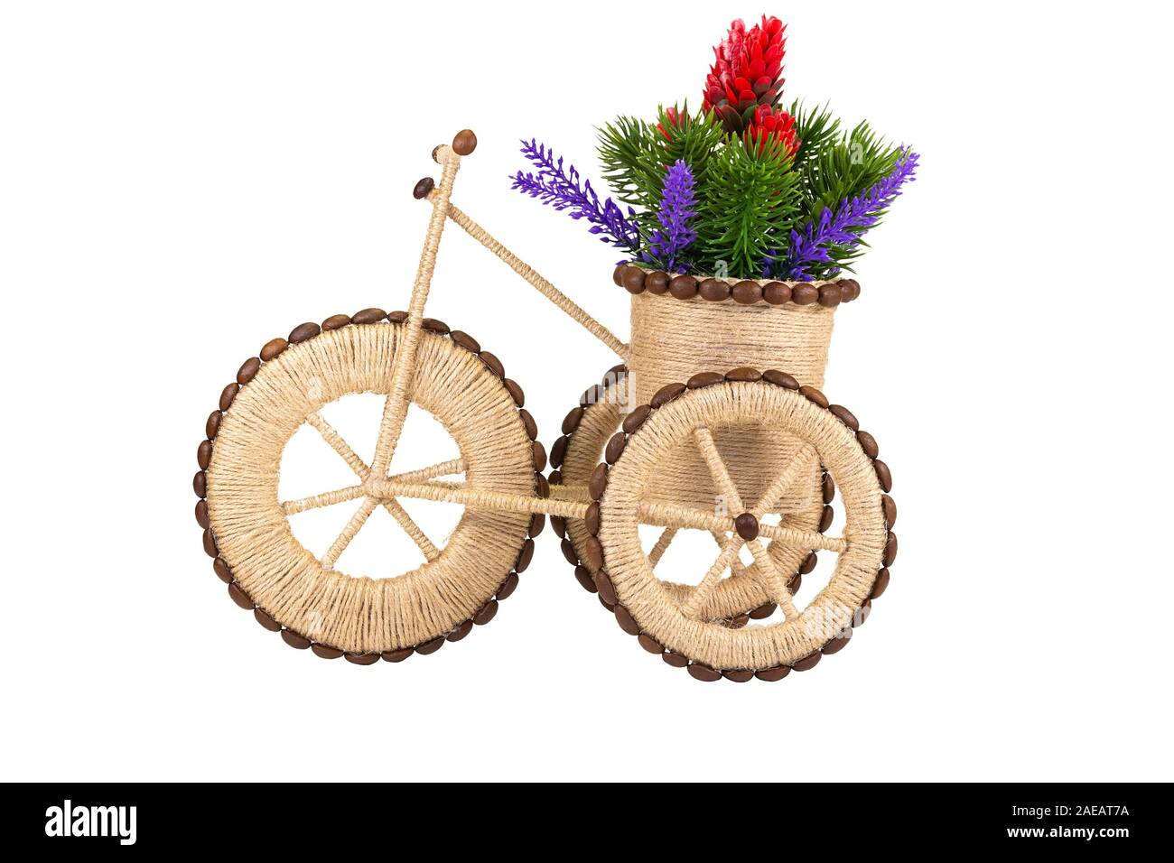 Stilisierte Dreirad mit einem Korb Blumen aus Garn und Kaffeebohnen. Hobbys und Handwerk. Isoliert auf weißem Stockfoto
