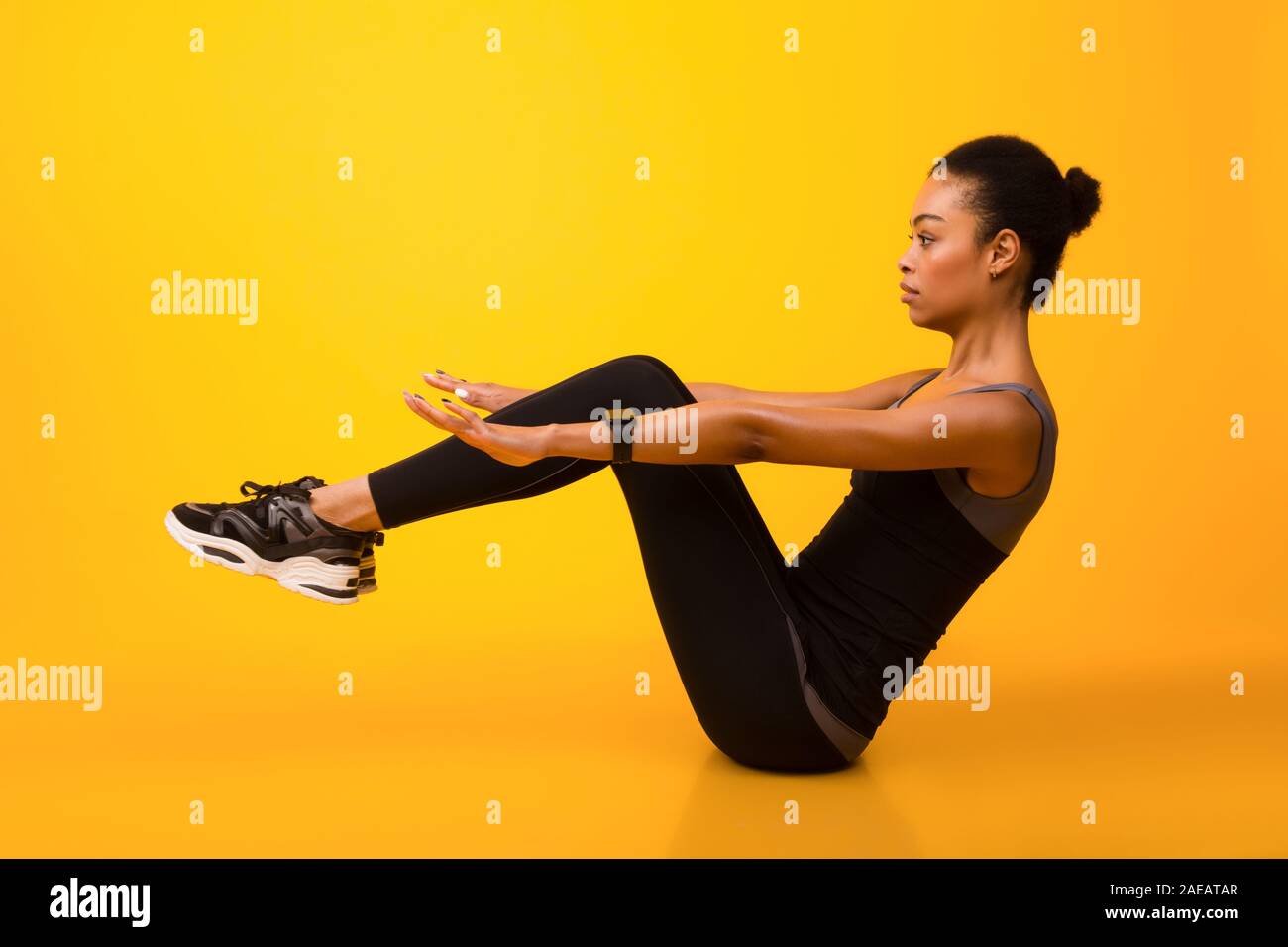 Afrikanische amerikanische Frau, ABS-Übung mit Bein heben, Studio Stockfoto
