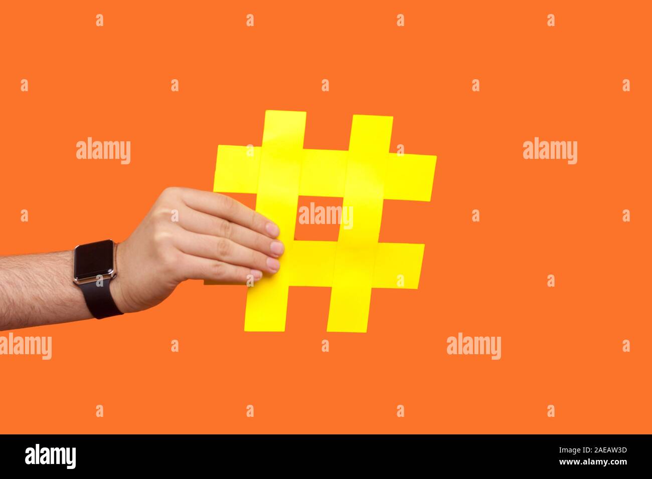 Nahaufnahme der männlichen Hand mit Armbanduhren mit großen gelben hashtag Zeichen, Zeit für virale Herausforderungen und Trends in der sozialen Medien, Internet blogging. ind Stockfoto